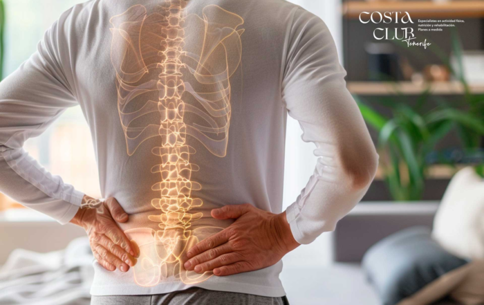 Artrosis-lumbar--qué-es-y-cómo-la-tratamos-en-Costa-Club-Tenerife - Costa Club Tenerife Person seen from behind with a glowing spine overlay on their back, hands on hips; Costa Club Tenerife logo in the background.